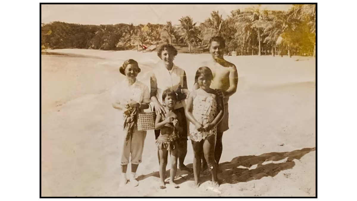 Napili Village Hotel, Vintage family photo on beach with woman, man, and three children. Palm trees in background.