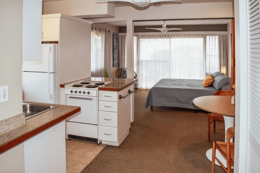 mini_studio_aa26ae_1fa8a38cf9cd4d80bd720a4f2979ef50~mv2_1_renamed Napili Village Hotel, Studio apartment interior with kitchen, bed, and dining area. Features small space living design.