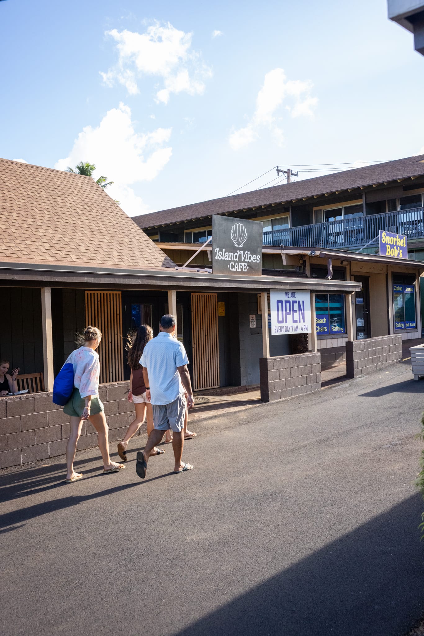 Napili Village Hotel, People walking past Island Vibes Cafe and Snorkel Bob's.