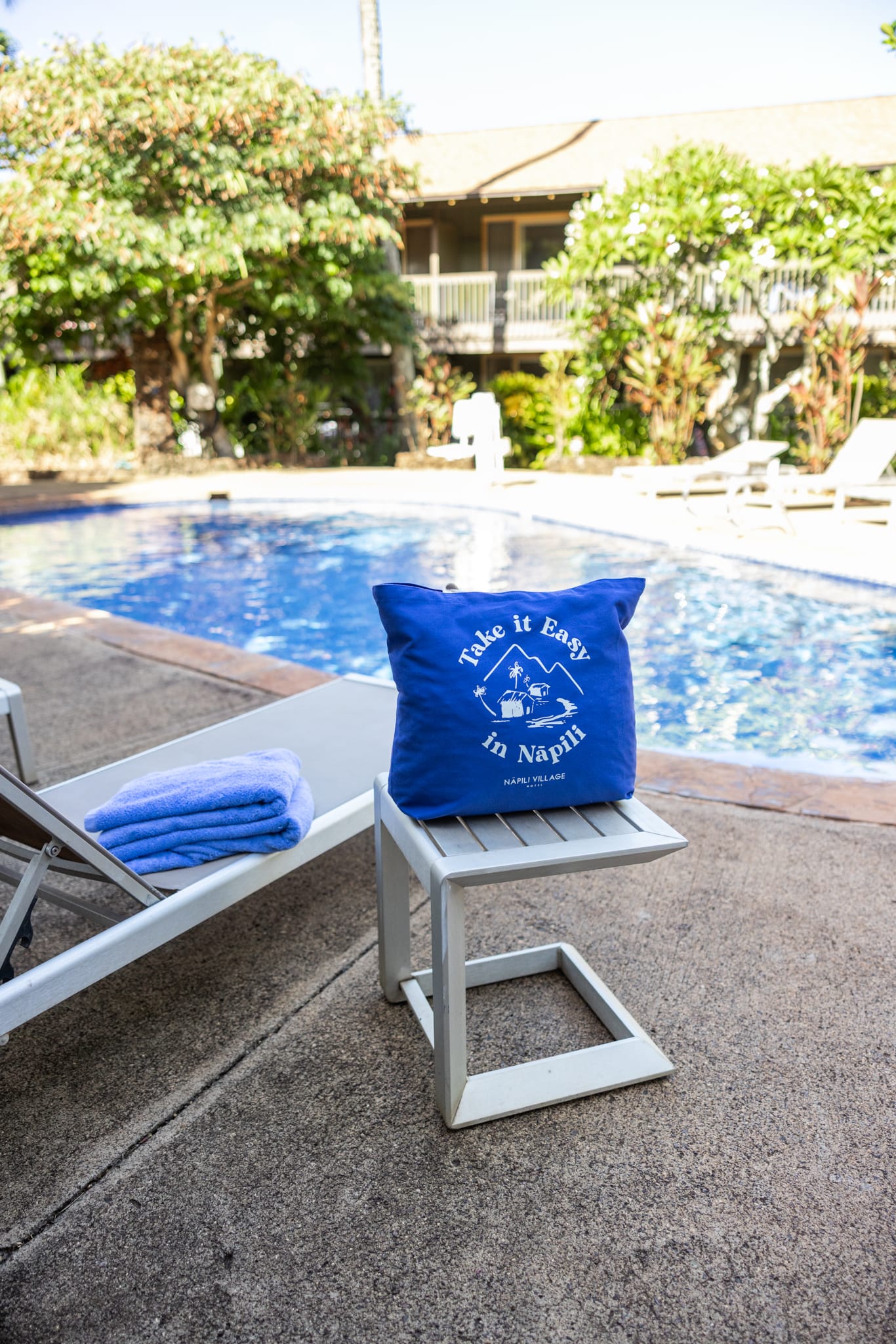 Napili Village Hotel, Blue pillow by a pool in Napili Village, reads "Take it Easy in Napili
