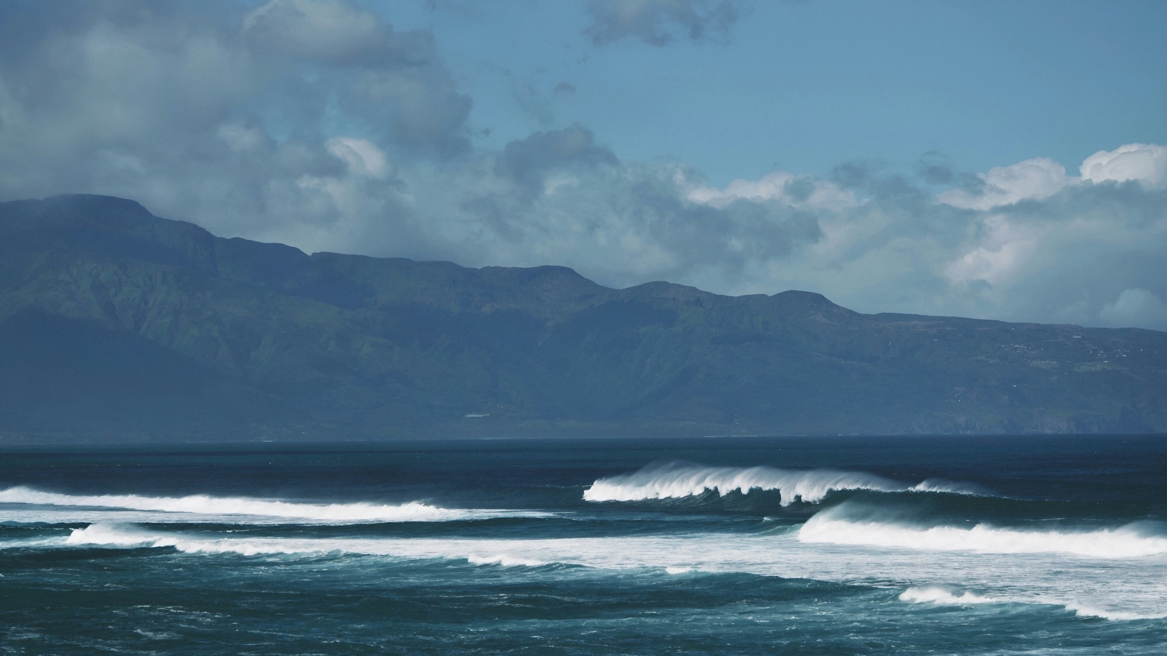 Napili Village Hotel, Waves crashing near the Road to Hana, with mountains in the background, Maui, Hawaii.