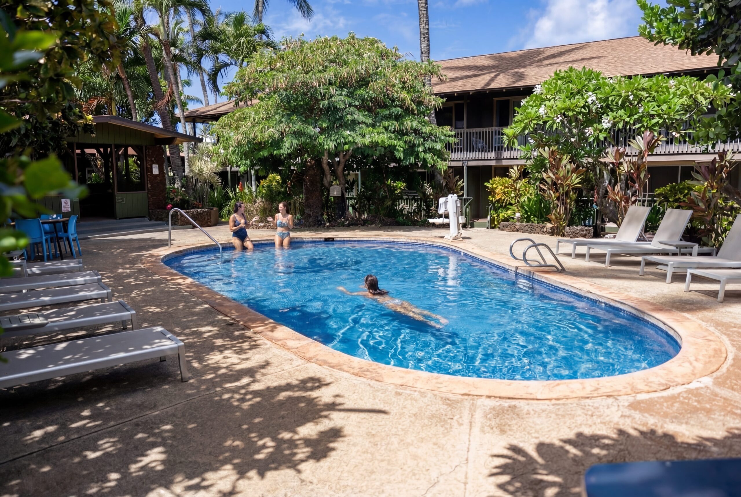 Napili Village Hotel, People enjoying a sunny pool at a tropical resort during a winter escape.