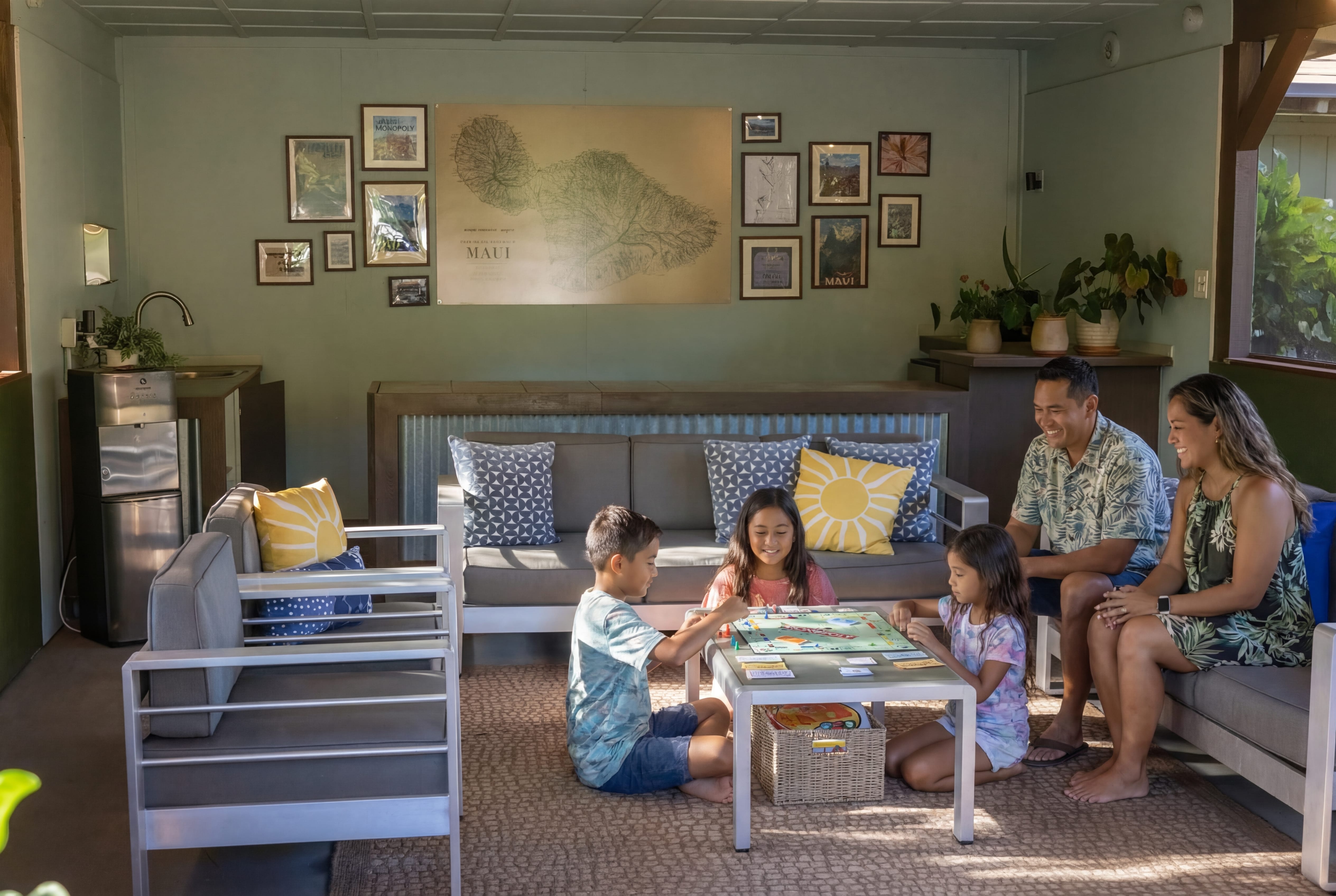 A family of four enjoys a board game together in a cozy lounge area with comfortable seating and a coffee table.